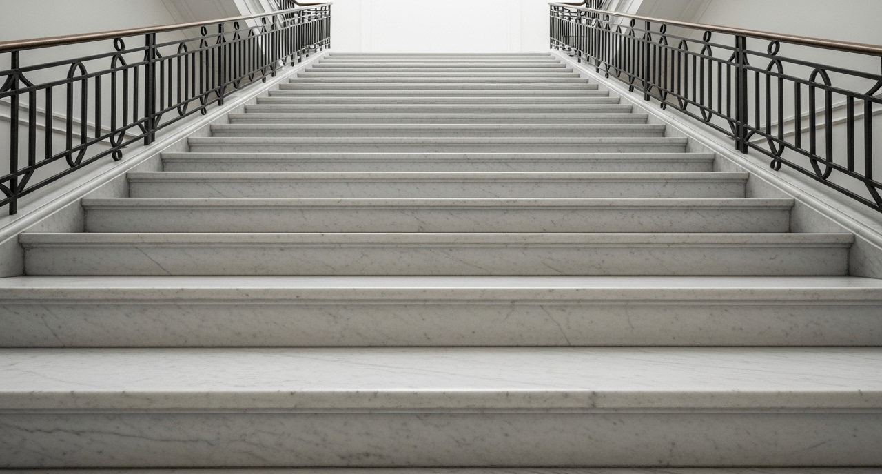 Imponente scala in marmo bianco che evidenzia il bisogno di un trattamento antiscivolo per garantire la sicurezza sui gradini